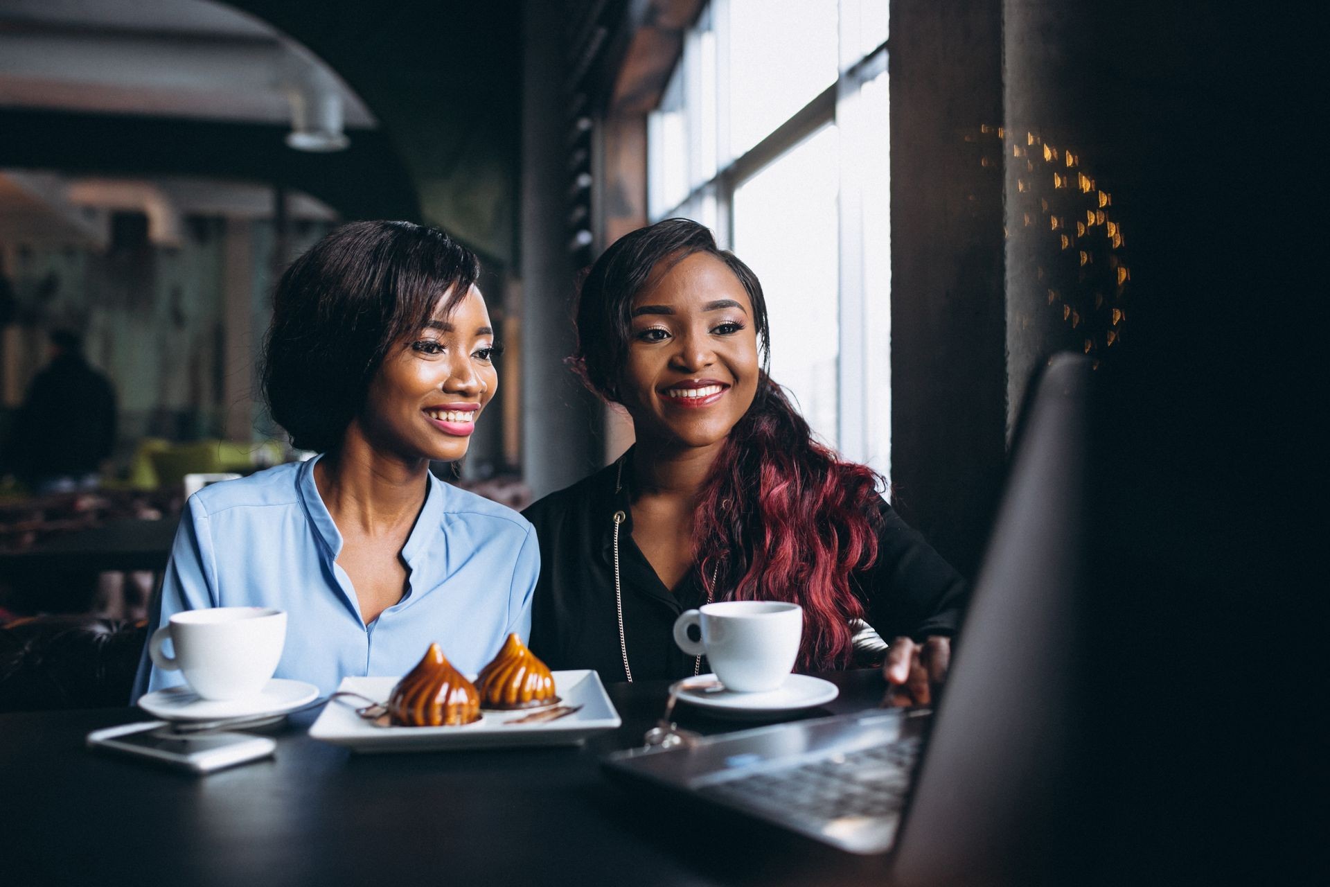 Two african american business woman in a cafe